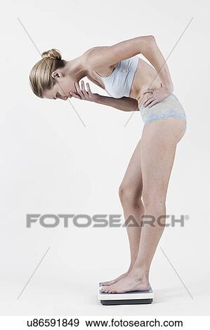 South Africa, Cape Town, Studio shot of young woman on bathroom scale View Large Photo Image Stock Photo - South Africa, Cape Town, Studio shot of young woman on bathroom scale. Fotosearch