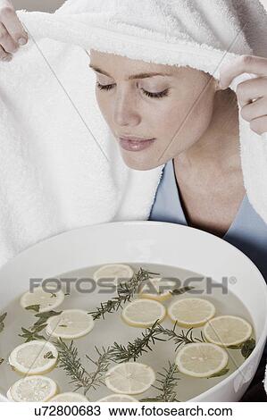 Stock Image - South Africa, Cape Town, Young woman inhaling vapors. Fotosearch