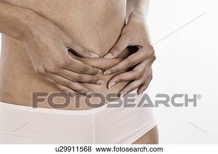 Stock Photo - South Africa, Cape Town, Young woman pinching folded skin, mid section. Fotosearch