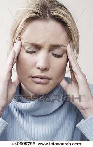 Stock Photograph - South Africa, Cape Town, Young woman rubbing temple. Fotosearch