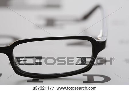 Stock Photo - Spectacles lying on eye chart. Fotosearch