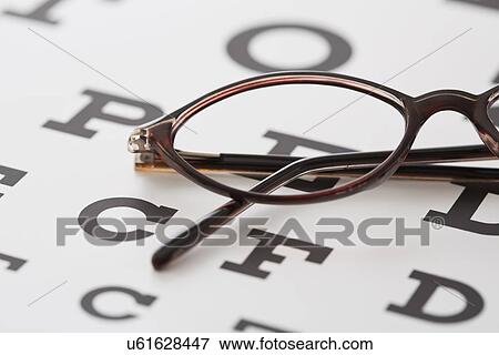 Stock Photo - Spectacles lying on eye chart. Fotosearch