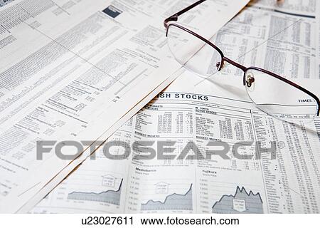 Stock Image - Spectacles on financial newspapers, close-up. Fotosearch