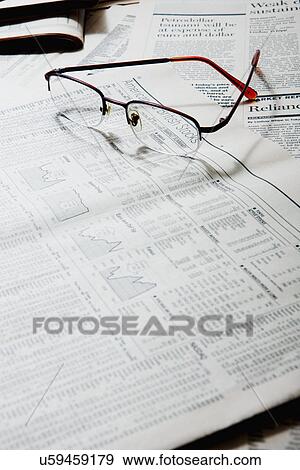 Stock Photo - Spectacles on financial newspapers, close-up. Fotosearch