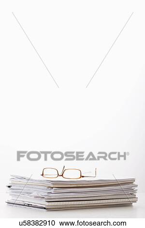 Stock Image - Spectacles on stack of documents. Fotosearch