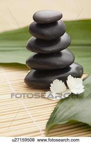Stock Photo - Stack of hot stone therapy stones in spa, Studio shot. Fotosearch
