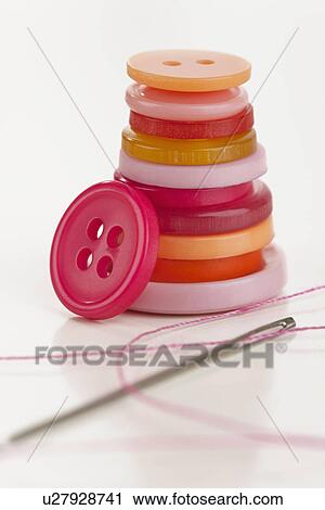 Stock Image - Stacked buttons with needle and thread. Fotosearch