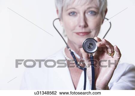 Studio portrait of female doctor holding stethoscope View Large Photo Image Stock Image - Studio portrait of female doctor holding stethoscope. Fotosearch