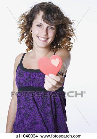 Studio portrait of smiling girl (10-11) holding heart shaped card View Large Photo Image Picture - Studio portrait of smiling girl (10-11) holding heart shaped card. Fotosearch