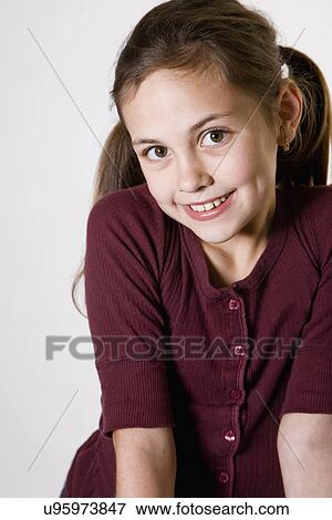 Stock Photo - Studio portrait of smiling girl (10-11). Fotosearch