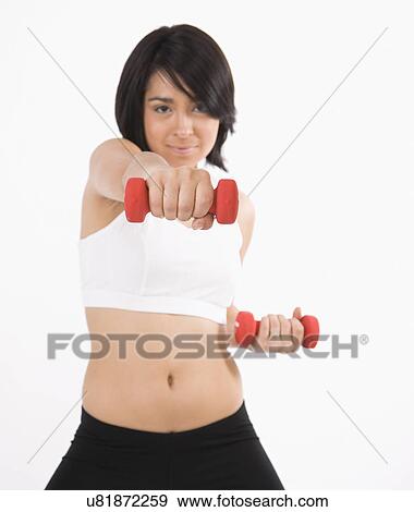 Studio portrait of young woman lifting dumbbells View Large Photo Image Stock Photo - Studio portrait of young woman lifting dumbbells. Fotosearch