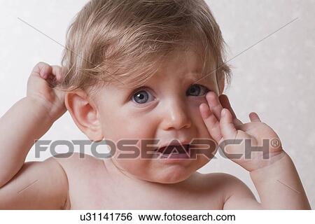 Stock Photograph - Studio shot of baby girl (12-17 months) crying. Fotosearch