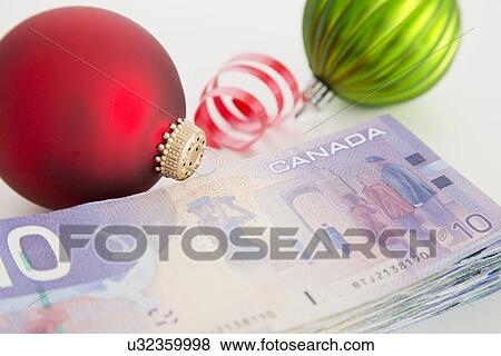 Stock Photo - Studio shot of banknotes and Christmas ornaments. Fotosearch