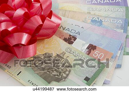 Stock Photo - Studio shot of banknotes and Christmas ornaments. Fotosearch