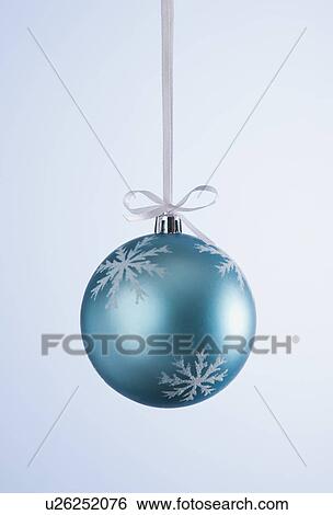 Stock Photograph - Studio shot of blue Christmas ornament hanging on ribbon. Fotosearch