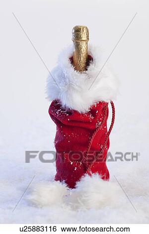 Stock Photograph - Studio shot of bottle of champagne in Christmas gift bag. Fotosearch