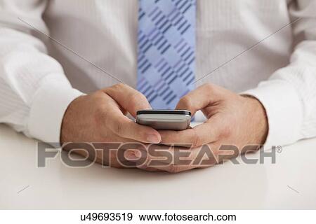 Studio shot of businessman text-messaging, midsection View Large Photo Image Stock Photo - Studio shot of businessman text-messaging, midsection. Fotosearch