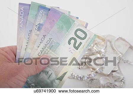 Stock Image - Studio shot of Canadian dollar bills and jewelry. Fotosearch