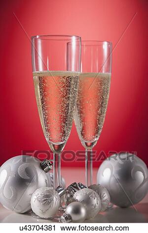 Studio shot of champagne flutes and Christmas ornaments View Large Photo Image Stock Image - Studio shot of champagne flutes and Christmas ornaments. Fotosearch