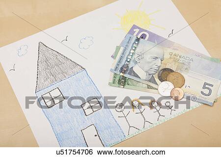 Stock Photograph - Studio shot of child's drawing of house and family and Canadian currency. Fotosearch