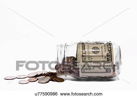 Stock Photograph - Studio shot of coins spilling out from jar. Fotosearch