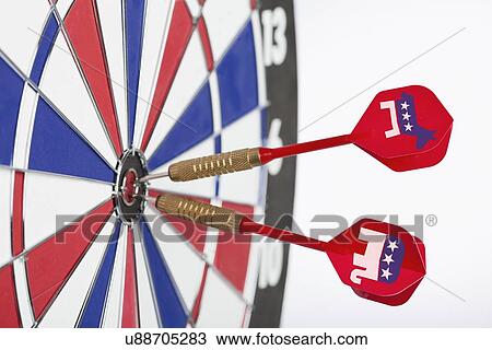 Stock Image - Studio shot of darts with political parties symbols in bull's-eye of dartboard. Fotosearch