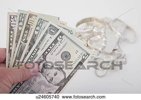 Stock Image - Studio shot of dollar bills and jewelry. Fotosearch