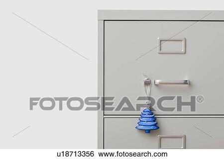 Studio shot of filing cabinet with small Christmas tree View Large Photo Image Stock Photograph - Studio shot of filing cabinet with small Christmas tree. Fotosearch