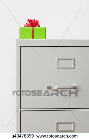Studio shot of gift on top of filing cabinet View Large Photo Image Stock Photo - Studio shot of gift on top of filing cabinet. Fotosearch