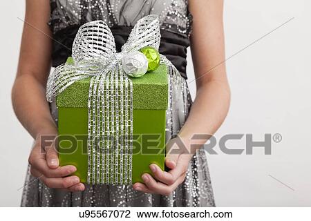 Studio shot of girl (12-13) holding gift in front of her View Large Photo Image Stock Image - Studio shot of girl (12-13) holding gift in front of her. Fotosearch