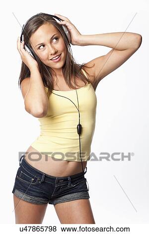 Stock Photo - Studio shot of girl (12-13) with headphones. Fotosearch