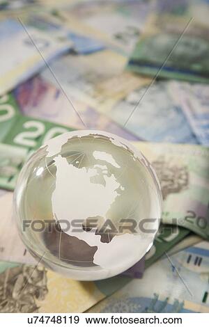 Studio shot of globe on banknotes View Large Photo Image Stock Photo - Studio shot of globe on banknotes. Fotosearch