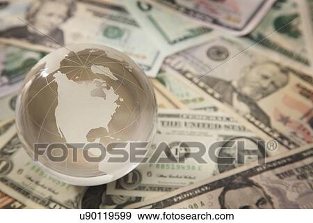 Stock Photo - Studio shot of globe on banknotes. Fotosearch