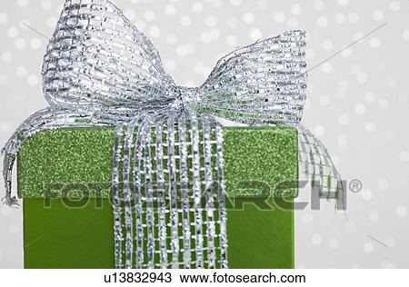 Studio shot of green gift with ribbon on sparkled background View Large Photo Image Stock Image - Studio shot of green gift with ribbon on sparkled background. Fotosearch