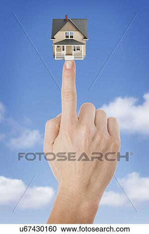 Studio shot of house model on woman's finger View Large Photo Image Stock Image - Studio shot of house model on woman's finger. Fotosearch