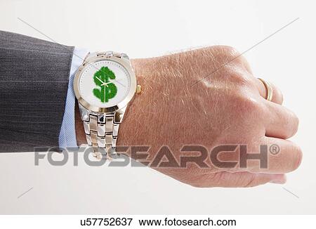 Stock Photo - Studio shot of male hand with wristwatch with grassy dollar sign. Fotosearch