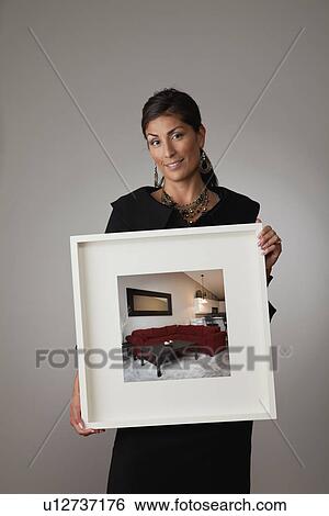 Studio shot of mature woman holding framed photograph View Large Photo Image Stock Photograph - Studio shot of mature woman holding framed photograph. Fotosearch