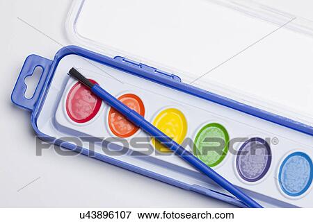 Stock Photo - Studio shot of multicolored paints and paintbrush. Fotosearch