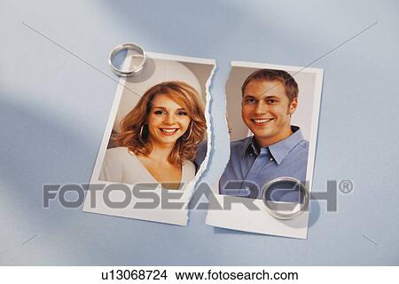 Picture - Studio shot of photo of couple torn in half and wedding rings. Fotosearch
