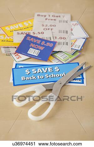 Stock Image - Studio shot of scissors and coupons. Fotosearch