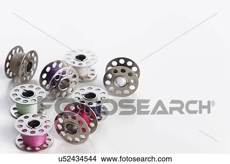 Picture - Studio shot of sewing machine bobbins of colored thread. Fotosearch