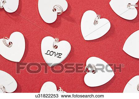 Stock Image - Studio shot of silver heart charms. Fotosearch
