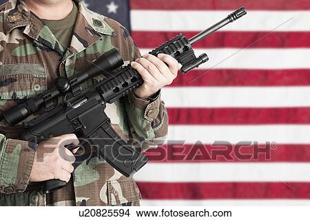 Studio shot of soldier with machine gun standing against American, mid section View Large Photo Image Picture - Studio shot of soldier with machine gun standing against American, mid section. Fotosearch