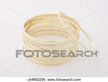 Studio shot of stack of golden bracelets View Large Photo Image Stock Photography - Studio shot of stack of golden bracelets. Fotosearch