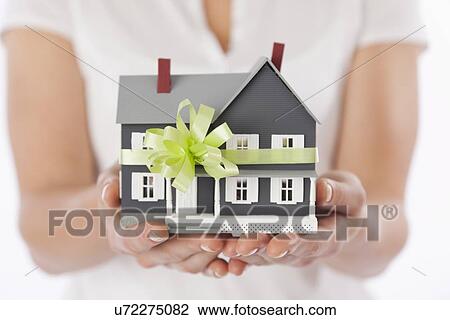 Studio shot of woman's hands holding model house View Large Photo Image Stock Image - Studio shot of woman's hands holding model house. Fotosearch