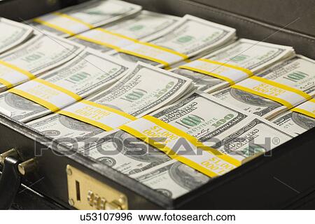 Stock Photograph - Suitcase filled with US currency notes. Fotosearch