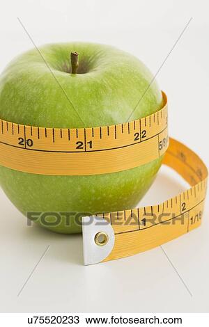 Stock Image - Tape measure around apple . Fotosearch