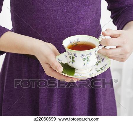 Stock Photo - Tea being poured into girl's (2-13) cup. Fotosearch