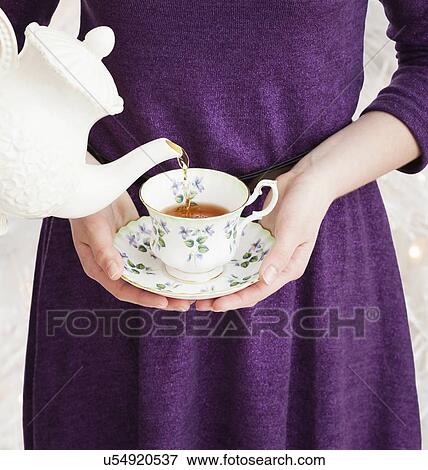 Tea being poured into girl's (2-13) cup View Large Photo Image Stock Photo - Tea being poured into girl's (2-13) cup. Fotosearch