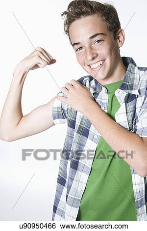 Stock Photograph - Teenage boy flexing muscles, portrait. Fotosearch